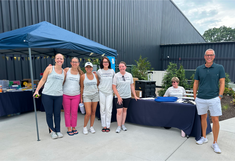 Teachers gathering under a tent at the annual Peepers back-to-school celebration party