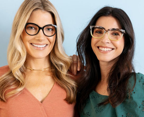 two women wearing black and gray/green reading glasses