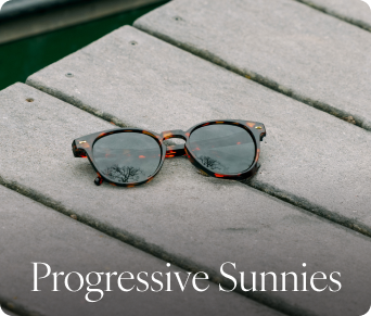 Sunglasses on a wooden surface with 'Progressive Sunnies' text.