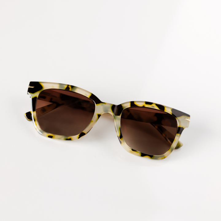 Sunglasses with tortoiseshell frame and brown lenses on a white background
