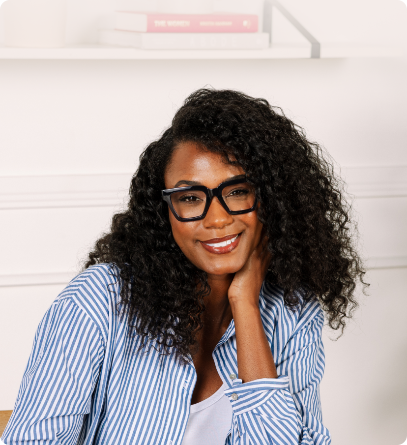 Woman wearing glasses and a blue striped shirt against a white background
