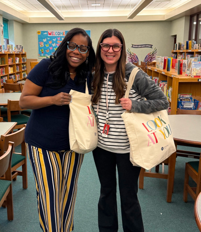 Students receiving Peepers tote bags filled with school supplies