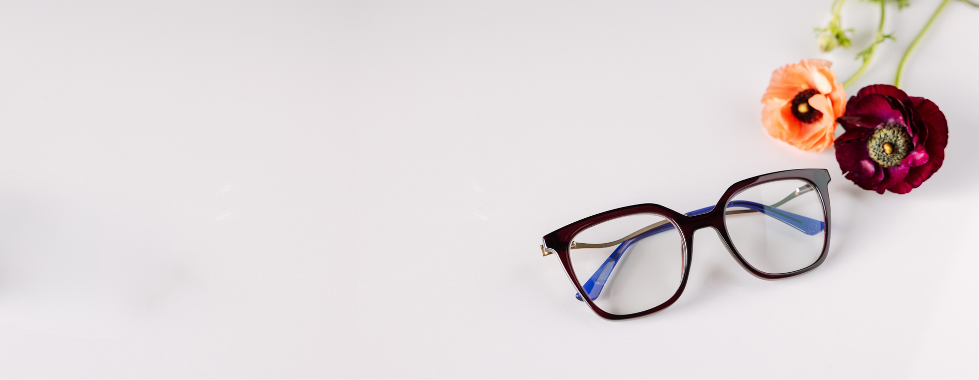 Main hero: Pair of eyeglasses with decorative flowers on a light background