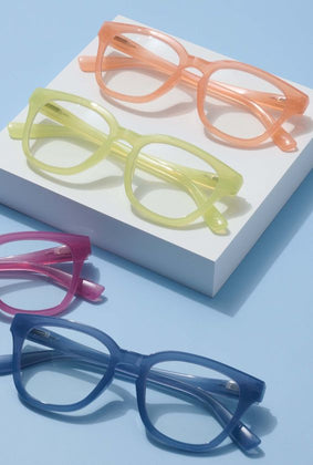four pairs of reading glasses, orange, pink, green, and blue